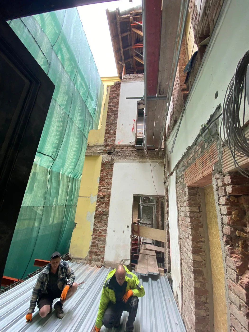 Pokrývači při práci na střeše domu na Jungmannově náměstí